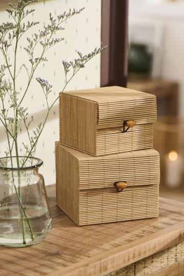 Två fyrkantiga förvaringsboxar i bambu med lock, liten och stor, staplade på en byra