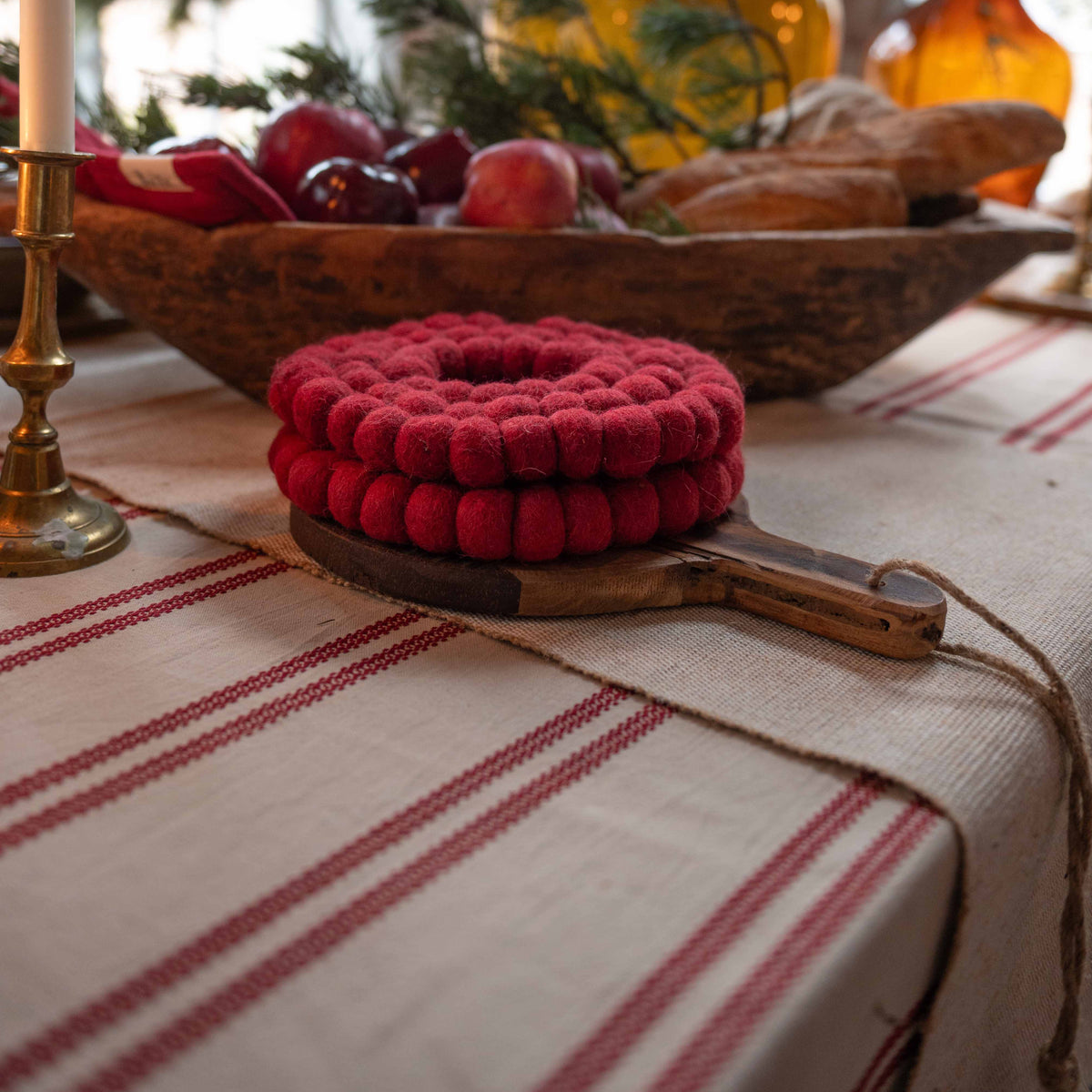 Närbild av julduken Hedvig med röda ränder på ett stämningsfullt dukat julbord