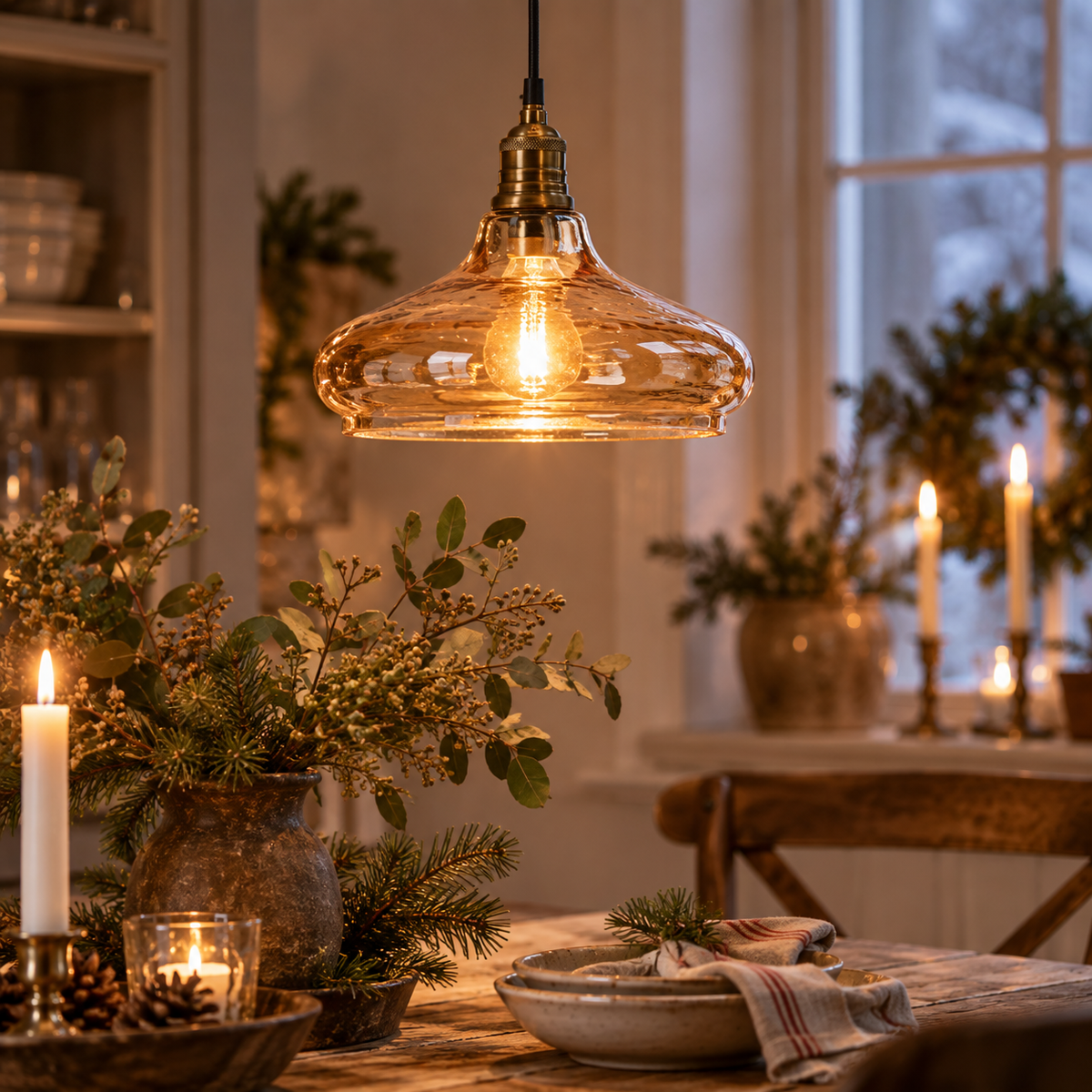 Tänd cognacfärgad taklampa i glas med vågig struktur över ett dukat matbord i varm vintermiljö