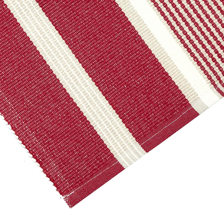 Närbild av bordslöpare Greta som är ribbad i olika breda ränder i julrött, vitt och beige.