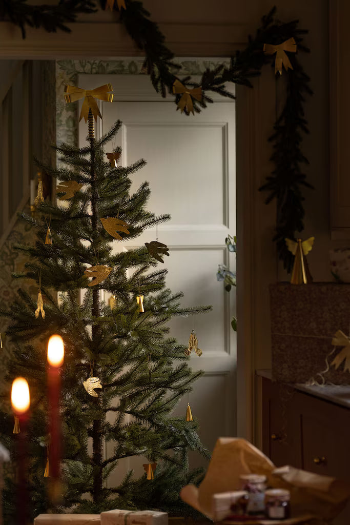 Julgran dekorerad med rosett som julgranstopp i mässingsfinish från Strömshaga