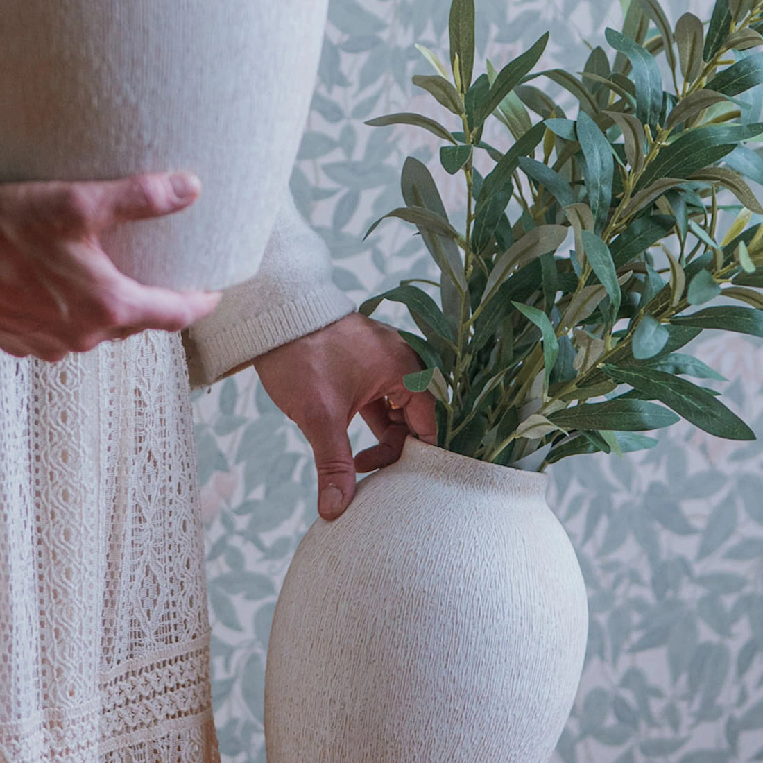 Konstgjorda olivkvistar med gröna blad arrangerade i vas