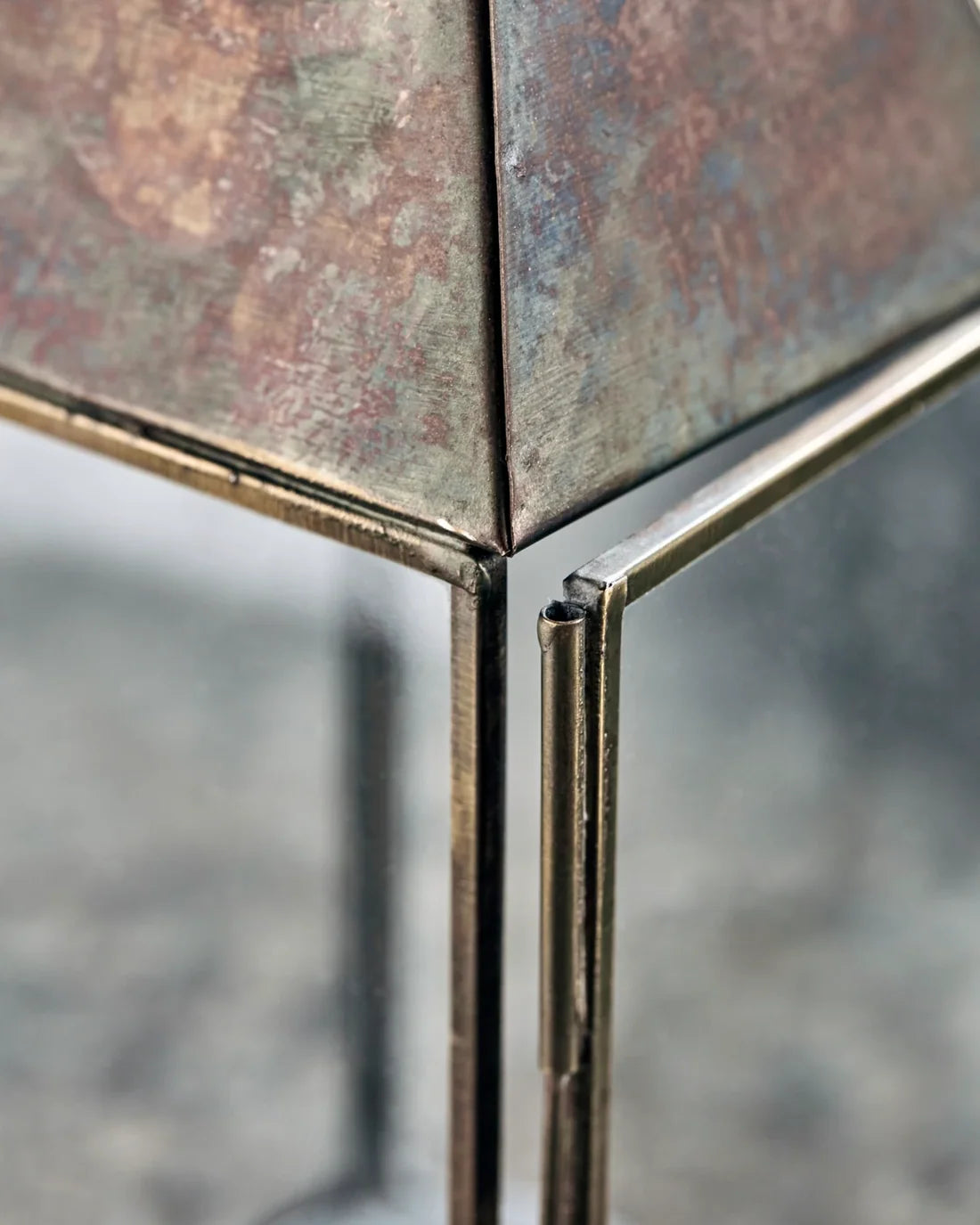 Detaljbild av öppning av ljuslykta Tilka i glas och järn med antik mässingsfinish, 23,5 cm hög.