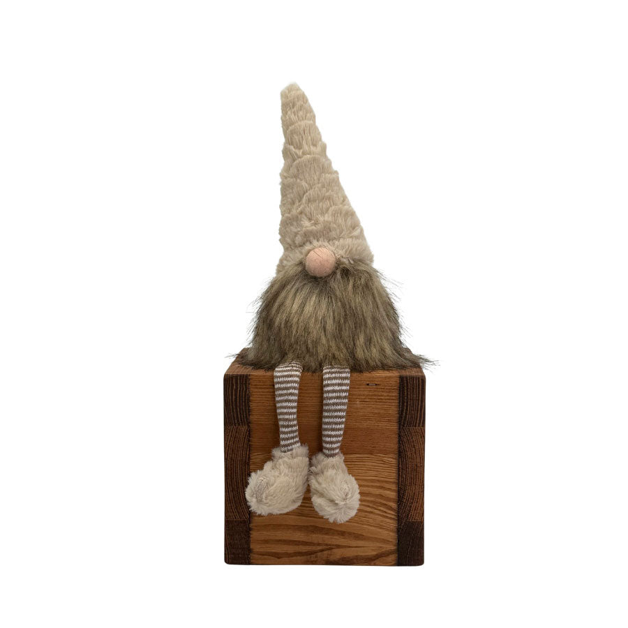 Liten tomte i naturfärger som sitter och dingla med benen över en hyllkant från Miljögården