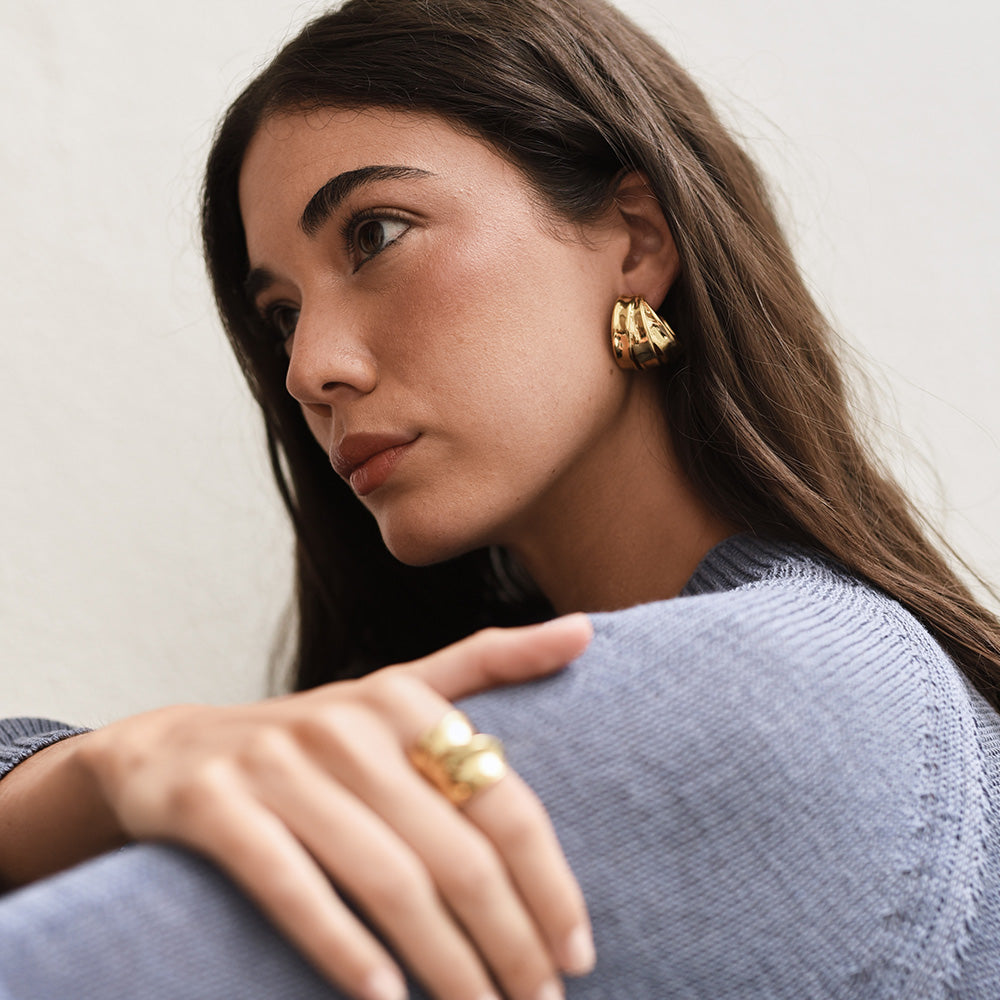 Breda skulpturala hoops burna som ett elegant smycke till vardagskläder