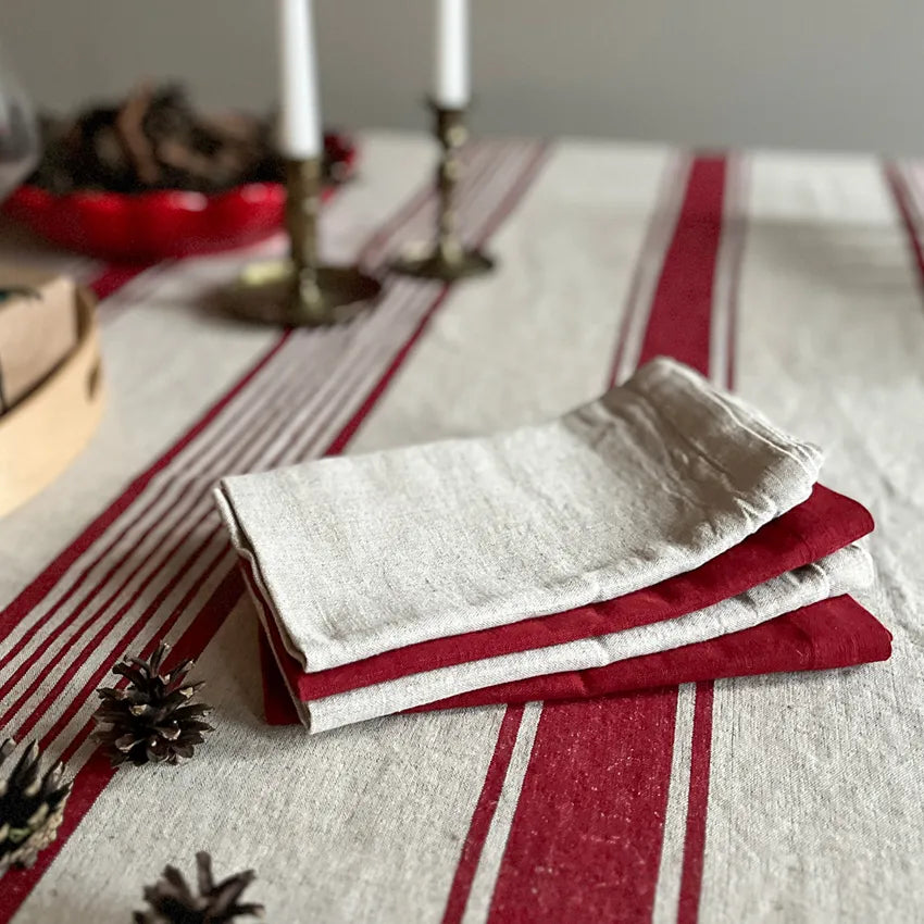Randig bordsduk i naturfärg med röda ränder i 70 procent lin och 30 procent bomull med matchande tygservetter
